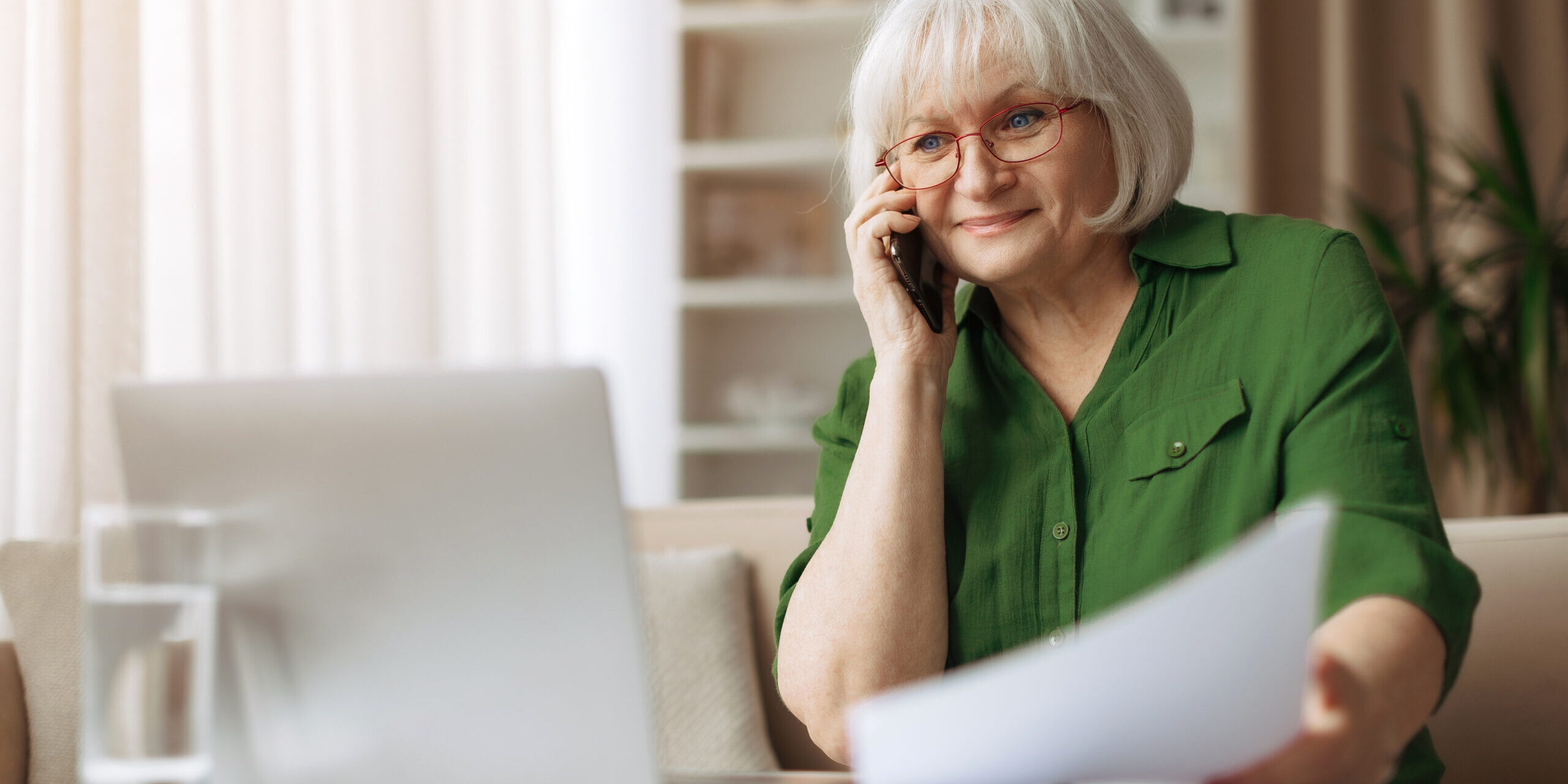 Senior woman smiling during phone call at home, elderly female enjoying communication and independence, warm retirement lifestyle with modern technology indoors